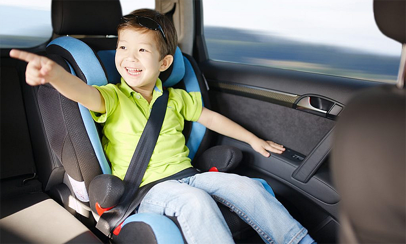 Trẻ nhỏ ngồi ở ghế riêng ở hàng ghế sau trên ôtô. Ảnh: Adobe